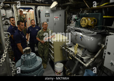 Lt. Kenneth Franklin, kommandierender Offizier der Coast Guard Cutter Oliver Berry (WPC 1124) zeigt Adm. Harry Harris, Jr., Commander, US Pacific Command, und hinten Adm. Vincent Atkins, Commander, Coast Guard 14. Bezirk, der Maschinenraum an Bord der Oliver Berry während einer schnellen Reaktion cutter Einweisungsrundgang bei Coast Guard Base Honolulu, Nov. 20, 2017. Diese Fräser mit der verbesserten Wirksamkeit bei Such- und Rettungsdiensten wird die Gewässer um die Inseln von Hawaii zu einem sichereren Ort für Freizeitboote und Nutzer der Wasserstraße. (U.S. Coast Guard Foto von Petty Officer 2. Klasse Tara M Stockfoto