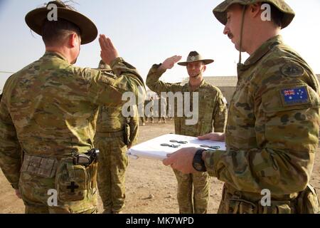 Oberstleutnant Giles Cornelia, kommandierender Offizier der dritten Bataillon, Royal Australian Regiment grüßt Oberst Steve D'Arcy vor dem Empfang einer australischen Operational Service Medal in Camp Taji, Irak, November 15, 2017. Camp Taji ist einer von vier Combined Joint Task Force - inhärenten Building Partner Kapazität beheben Standorte Ausbildung Partner Kräfte und Verstärkung ihrer Wirksamkeit auf dem Schlachtfeld gewidmet. CJTF-OIR ist die globale Koalition zu besiegen ISIS im Irak und in Syrien. (U.S. Armee Foto von Cpl. Rachel Diehm) Stockfoto