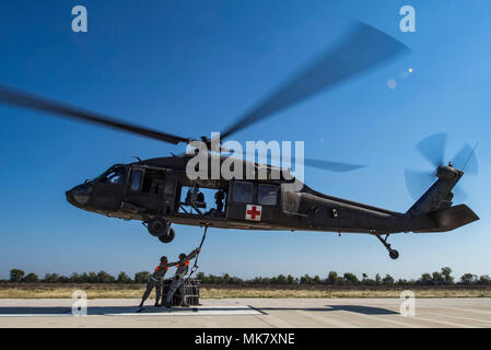 Flieger vom 26. Antenne Anschluss Squadron eine A-22 cargo Tasche mit 2.000 Pfund von "Hilfsgütern", die die Ladung Haken des UH-60 Black Hawk Hubschrauber von Soldaten aus Texas Army National Guard Firma C geflogen, 2-149 Luftfahrt während des Betriebs Alamo Evakuierung November 18, 2017, Martindale Army Airfield, Texas. 36.000 Pfund von Fracht und 27 Passagiere wurden als Teil der Schlinge legen und medizinische Evakuierung transportiert. (U.S. Air Force Foto von älteren Flieger stürmischen Archer) Stockfoto