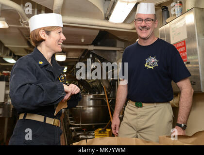 Pazifik (Nov. 22, 2017) US Navy Lieutenant Cmdr. Theresa Donnelly, aus Columbus, Ohio, und Cmdr. Michael Mulhern von Brandon, Fla., die Pappe Pause während einer Mustang Assoziation Chaos deck Übernahme in die kombüse der Flugzeugträger USS Nimitz (CVN 68), November 22, 2017, im Pazifischen Ozean. Der Nimitz Carrier Strike Group ist auf einem regelmäßig geplanten Einsatz in den Westpazifik. Die US-Marine hat die Indo-Asia-pazifischen Region routinemäßig für mehr als 70 Jahre Frieden und Sicherheit patrouillierte. (U.S. Marine Foto von Mass Communication Specialist Seaman Jose Madrigal) Stockfoto