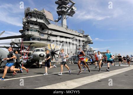 171123-N-KB 563-1124 INDISCHER OZEAN (Nov. 23, 2017) Matrosen und Marines über die Flight Deck während des Thanksgiving Türkei Trab 5K an Bord der Flugzeugträger USS Theodore Roosevelt (CVN 71). Theodore Roosevelt ist zur Unterstützung der Maritime Security Operations und Theater Sicherheit Zusammenarbeit bereitgestellt werden. (U.S. Marine Foto von Mass Communication Specialist 1. Klasse Michael Russell/Freigegeben) Stockfoto