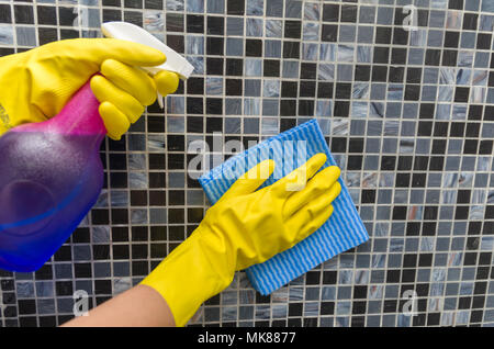 Großes Haus Reinigung Konzept, Handschuh Abwischen der Hände Fliesen an der Wand. Stockfoto