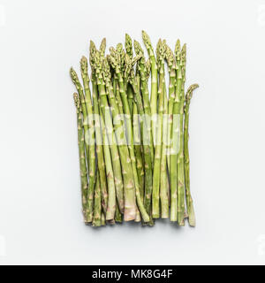 Grüner Spargel Bündel auf weißem Hintergrund, Ansicht von oben, flach. Gesunde saisonale Speisen Stockfoto