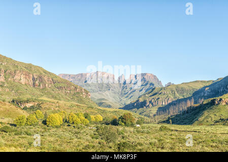 INJISUTHI, SÜDAFRIKA - 21. MÄRZ 2018: Der Rest Camp zwischen Bäumen in Injisuthi im Maloti Drakensberg Park mit Sekt Schloss, Monks Cowl ein Stockfoto