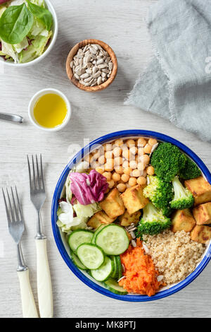 Bunte buddha Schüssel, gesunden vegetarischen Salat. Buddha Schüssel mit süssen Kartoffeln, Quinoa, Kichererbsen, Brokkoli, baked Tofu, Gurken und grünem Salat Blatt. Stockfoto