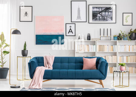 Rosa Decke auf marine blau Sofa in modernes Wohnzimmer mit Galerie der Poster an der Wand Stockfoto