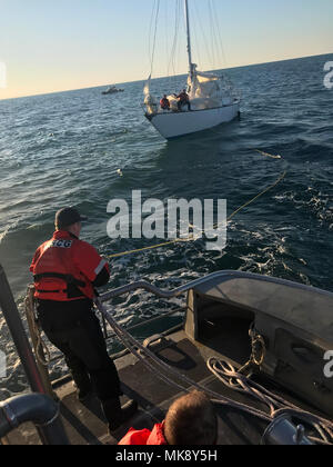 Coast Guard Seemanns John Warren, ein Crew Mitglied an der Coast Guard Station Hatteras Inlet, neigt der Linie beim Abschleppen eines Segelboot nehmen auf Wasser, 13 km östlich von Hatteras Island, North Carolina, November 26, 2017. Die Küstenwache 47-Fuß-Motor Life Boat Crew das Segelboot zu Oden's Dock auf Hatteras Island geschleppt. (U.S. Coast Guard Foto von Petty Officer 2. Klasse Chuck Seckinger/Freigegeben) Stockfoto