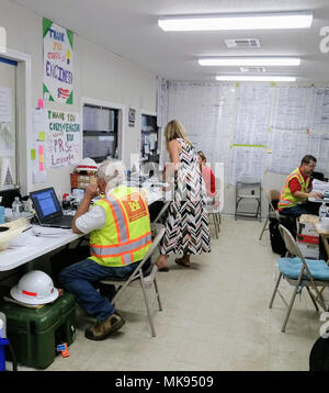 FORT BUCHANAN, Puerto Rico - Antillen Lehrer der mittleren Schule Laura Soldevila, Mitte, bereitet einem der Plakate in der Power Team office Trailer als Kit Tressler, Nachtschicht mission Manager, Links, und Glen Clifton, rechts, Logistiker, weiter daran arbeiten, die Mission zu beenden. Stockfoto