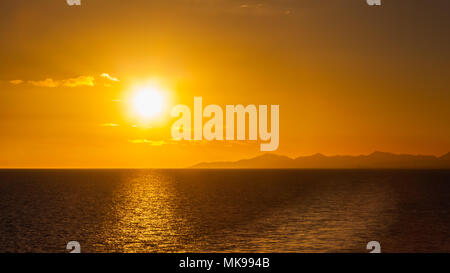 Lanzarote Sonnenuntergang. Sonnenuntergang über der Küste der spanischen Kanareninsel Lanzarote. Eine Yacht gesehen werden kann, die unter der Sonne am Horizont. Stockfoto