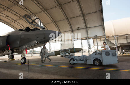 Us Air Force Airman 1st Class Samil Harkness, Senior Airman Jakob Krämer und Staff Sgt. David Panzer, 33 Aircraft Maintenance Squadron Waffen laden Besatzungsmitglieder, Position ein Joint Direct Attack Munition GBU-31 vor einer F-35A Lightning II Dez. 1, 2017, in Eglin Air Force Base, Fla. Last Crews aus der 33 Fighter Wing jeden Monat durchführen mindestens erforderlichen Kenntnissen Last (MPRL) ihre Fähigkeit und Kenntnisse der Munition und deren Beladen Fähigkeit ist zu gewährleisten. Die Fähigkeit, Waffen auf ein Flugzeug schnell zu laden und effizient ermöglicht Piloten in der Ausbildung die Sortie zu fliegen Stockfoto