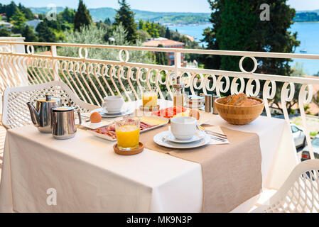 Kontinentales Frühstück Tisch mit Meerblick serviert. Hotel Restaurant Buffet Frühstück wird auf einem Balkon in der Nähe des Meer serviert. Ferienhäuser Stockfoto