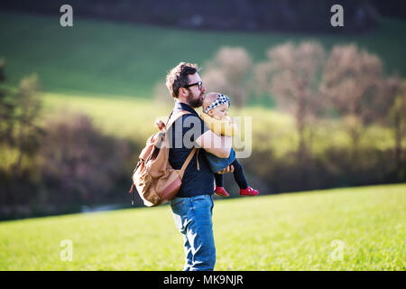 Ein Vater mit seinem Kind Tochter außerhalb im Frühjahr die Natur.
