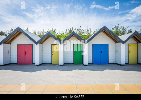 Bunten Badekabinen stand in der Nähe der Küste an einem warmen sonnigen Nachmittag in der Küstenstadt Swanage, Dorset, Großbritannien. Stockfoto