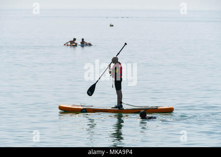 Lyme Regis, Dorset, Großbritannien. 7. Mai 2018. UK Wetter. Ein paddleboarder auf dem Wasser in den Badeort Lyme Regis in Dorset genießen die heißen sonnigen Feiertag Montag. Foto: Graham Jagd-/Alamy leben Nachrichten Stockfoto