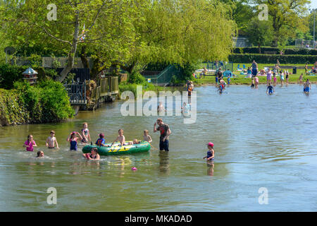 Familien genießen einen Feiertag hitzewelle am Flussufer und Abkühlung im Wasser des Flusses Avon in Berka/Werra, Hampshire, UK, Mai 2018. Ein heisser, sonniger Tag mit Temp.-Aufzeichnungen in den gesamten südlichen England gebrochen wird. Stockfoto