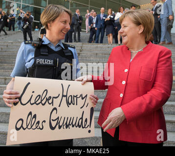 Frankfurt am Main, Deutschland. 7. Mai, 2018. Die deutsche Bundeskanzlerin Angela Merkel (CDU) hat die Polizei Offizier Susanne Rohlfing, der mit einem Schild mit dem Text "Lieber Harry, beste Wünsche!", nachdem die CDU/CSU-Fraktion Chairpeople Conference in der Commerzbank Tower. Die Offiziere der 1 Revier Abschied mit dem Zeichen zu einem Kollegen, der in den Ruhestand Nach 40 Jahren ist. Foto: Boris Roessler/dpa Quelle: dpa Picture alliance/Alamy leben Nachrichten Stockfoto