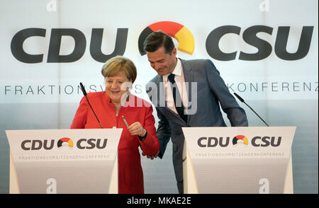 Frankfurt am Main, Deutschland. 7. Mai, 2018. Mike Mohring (R), der Vorsitzende der Konferenz- und Fraktionsvorsitzende der CDU im Landtag (Legislative) von Thüringen, und die deutsche Bundeskanzlerin Angela Merkel ihre Plätze (CDU) auf einer Pressekonferenz im CDU/CSU-Fraktion Chairpeople Conference in der Commerzbank Tower. Eines der wichtigsten Themen in diesem Gipfeltreffen war Flüchtlings- und Migrationspolitik. Foto: Arne Dedert/dpa Pool/dpa Quelle: dpa Picture alliance/Alamy leben Nachrichten Stockfoto
