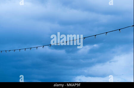 Reihe von Glühlampen Glühlampen durch eine Straße Lamm post hängen. Stockfoto