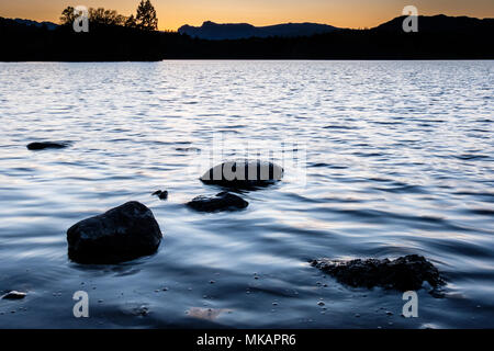 In Windermere, von der Fischerei Howe, in der Nähe von Low Wray, gegenüber den Langdale Pikes bei Sonnenuntergang, Lake District, Cumbria Stockfoto