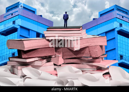Der Mann stand auf der Oberseite der Bücher Stockfoto