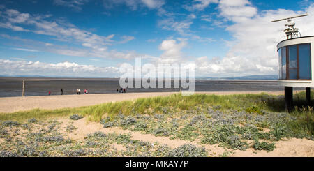 Die Menschen entlang der Sand von Fleetwood Beach in der Nähe von Blackpool, Lancashire, mit den Bergen des Lake District und die Firma Bowland in der Ferne acros Stockfoto
