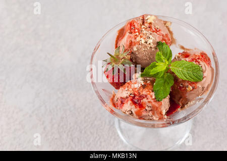 Eis mit Erdbeeren in einem Glas Vase auf einem leicht gerippte Oberfläche. close-up. Der Blick von oben Stockfoto