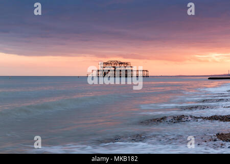 Vivid pink und orange Sonnenuntergang und West Pier von Brighton Beach, East Sussex, UK. Stockfoto