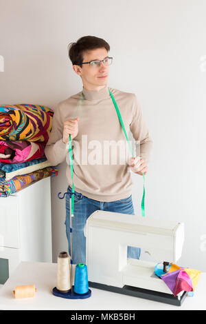 Patchwork, Technologie, Tradition Konzept. Es gibt jungen, aber erfahrenen maßgeschneiderte Brillen und leichte Pullover, der sich vom Schreibtisch mit ele Stockfoto