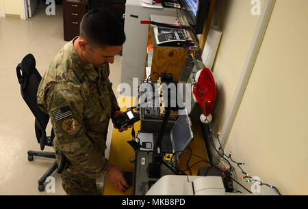 Tech. Sgt. Andrew Blackmon, 430Th Squadron Expeditionary Electronic Combat aircrew Flug Ausrüstung Techniker, prüft das Überleben radios Nov. 28, 2017 in Kandahar Airfield, Afghanistan. Blackmon stellen das Überleben Komponenten; Air Crew Body Armour, Bekämpfung der Überlebenden evader Locator, Radios und jede andere Art von Unterstützung die Piloten für ihre täglichen Aufgaben. (U.S. Air Force Foto/Staff Sgt. Göttliche Cox) Stockfoto