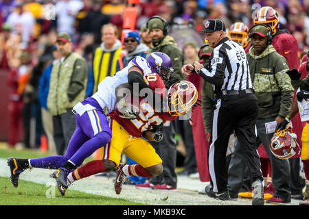 Washington Redskins zurück laufen Rob Kelley (20) Out of Bounds durch ein Minnesota Vikings Verteidiger während eines Spiels zwischen den Minnesota Vikings und die Washington Redskins, Nov. 12, 2017 FedEx Field in Landover, Md. Die Redskins Organisation geehrt Aktuelle und ehemalige US-Militärs während der an diesem Tag eine Vernietung ist ein Gruß an Service angegangen wird. (U.S. Armee Foto von Ricky Bowden) Stockfoto