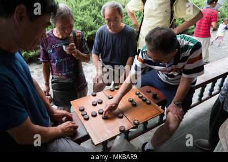 Chinesische Männer spielen traditionelle checkers Spiel in Peking, China, Asien. Freunde Spaß mit Freizeitaktivitäten Aktivität Stockfoto
