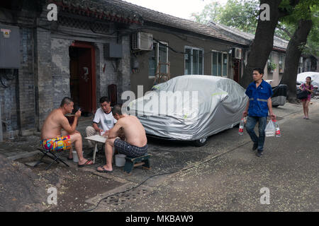 Chinesische Männer spielen Karten Spiel in Peking, China, Asien. Freunde Spaß mit Freizeitaktivitäten Aktivität in einem Hutong (traditionelle Alte Gasse) Stockfoto