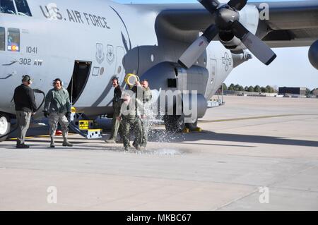 Master Sgt. Victor Cowen, ein 302Nd Airlift Wing Hercules C-130 Flugzeugen Mannschaft Leiter, wird mit Wasser von Master Sgt übergossen. Jason Harvey, ein 731St Airlift Squadron C-130 Lademeister, nach ihrer Rückkehr aus Cowens final C-130 Flug, bei Peterson Air Force Base, Colo, November 20 2017. Cowen, der sowohl als traditionelle Reservist und Luft finden Techniker mit dem 302Nd Wartung Gruppe seit 2002, nach fast 36 Jahren der militärischen Dienst, der 9-Implementierungen enthalten in den Ruhestand. (U.S. Air Force Foto/Daniel Butterfield) Stockfoto