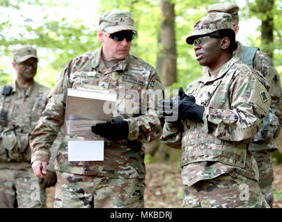 Chemical Corps Command Sgt. Maj. Henney Hodgkins (rechts) bespricht ihre Beobachtungen der Chemischen Self-Assessment und Mitigation (CSAM) Tasche mit pensionierten US-Armee Maj. Joseph Call, Chief experimentieren Koordinator mit der gemeinsamen Experimente und Analyse Abteilung der Gemeinsamen CBRN-Bekämpfung Entwicklungen, während eines chemischen Angriff übung Prüfung die Fähigkeit der taktischen Dekontamination am 3. Mai 2018 Joint Warfighting Bewertung (JWA) 18, in Hohenfels, Deutschland. JWA wertet Konzepte und Fähigkeiten in einer realistischen und konsequente Weiterbildung Umwelt ein bereit, flexibel und anpassungsfähig zu bauen futu Stockfoto