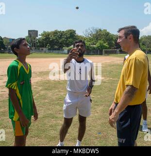 180504-N-NH 199-0270 TRINCOMALEE, Sri Lanka (Mai 5, 2018) Hospital Corpsman 2. Klasse Patrick Langon, von Shelton, Washington, zugeordnet zu den Hubschrauber Meer Combat Squadron 23 (HSC 23) an Bord Military Sealift Command Hospital Ship USNS Mercy (T-AH 19) wartet als Schiedsrichter Münzwürfe, um zu entscheiden, wer erhält den Ball während eines gemeinschaftlichen Beziehungen Fußball Spiel und band Leistung. Barmherzigkeit ist derzeit zur Unterstützung der pazifischen Partnerschaft 2018 (PP18) bereitgestellt werden. PP18's Mission ist es, gemeinsam mit Gastgeber und Partner Nationen zu arbeiten regionaler Interoperabilität und Disaster Response Fähigkeiten zu verbessern, erhöhen. Stockfoto