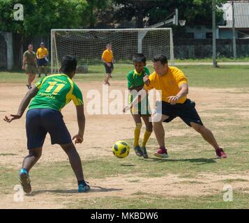 180504-N-NH 199-0270 TRINCOMALEE, Sri Lanka (Mai 5, 2018) Hospital Corpsman 2. Klasse Patrick Langon, von Shelton, Washington, zugeordnet zu den Hubschrauber Meer Combat Squadron 23 (HSC 23) an Bord Military Sealift Command Hospital Ship USNS Mercy (T-AH 19) geht für den Ball während eines gemeinschaftlichen Beziehungen Fußball Spiel und band Leistung. Barmherzigkeit ist derzeit zur Unterstützung der pazifischen Partnerschaft 2018 (PP18) bereitgestellt werden. PP18's Mission ist es, gemeinsam mit Gastgeber und Partner Nationen zu arbeiten regionaler Interoperabilität und Disaster Response Funktionen, erhöhen die Stabilität und Sicherheit in der Region zu stärken und fördern. Stockfoto