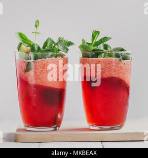 Serviert Gläser mit hellen Limonade der Wassermelone und Minze auf weißem Hintergrund. Stockfoto