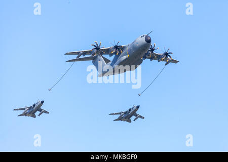BERLIN/Deutschland - am 28. APRIL 2018: Military Airbus A400M Flugzeug fliegt mit zwei multirole Panavia Tornado Kampfflugzeuge am Flugplatz Scho Stockfoto