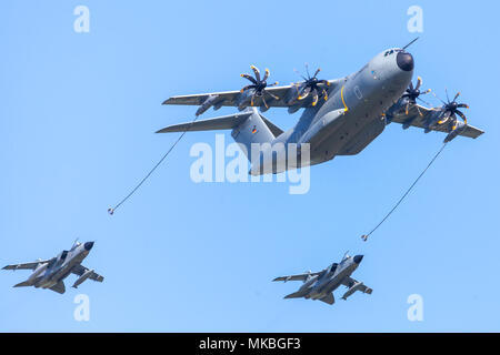 BERLIN/Deutschland - am 28. APRIL 2018: Military Airbus A400M Flugzeug fliegt mit zwei multirole Panavia Tornado Kampfflugzeuge am Flugplatz Scho Stockfoto