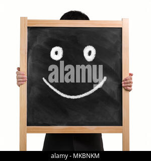 Der Mann zwei Hände heben bis schwarze hölzerne Tafel mit Zeichnung Smiley, auf weißem Hintergrund. Stockfoto
