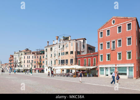 Farbenfrohe Gebäude auf Riva dei Sette Martiri, Castello, Venedig, Venetien, Italien mit Menschen zu Fuß entlang der Promenade genießen Sie die Frühlingssonne Stockfoto