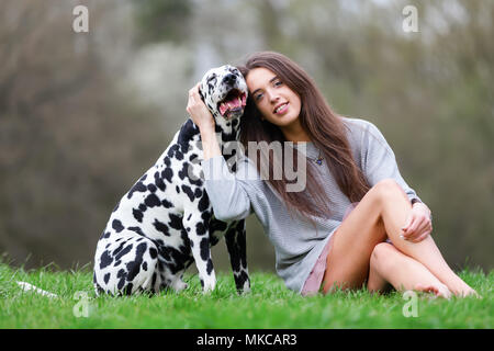 Porträt einer schönen jungen Frau mit ihrem Dalmatiner Hund Stockfoto