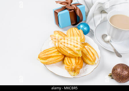 Tasse Kaffee mit Milch, Kanne mit Milch, Kugel und Geschenke für Weihnachten Frühstück auf einem weißen Hintergrund. Serviert werden. Ansicht von oben, kopieren Raum Stockfoto