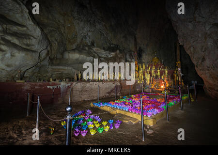 Viele goldene Buddha Statuen und bunten Papier Blumen innerhalb der Tham Theung Höhle zu den berühmten Höhlen von Pak Ou in der Nähe von Luang Prabang in Laos. Stockfoto