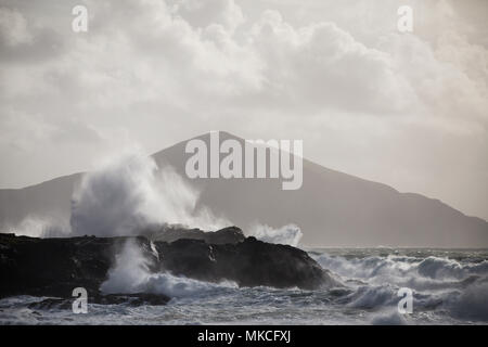 Wellen an der Küste von Achill Island, County Mayo Irland mit Clare Insel im Hintergrund zu brechen. Stockfoto