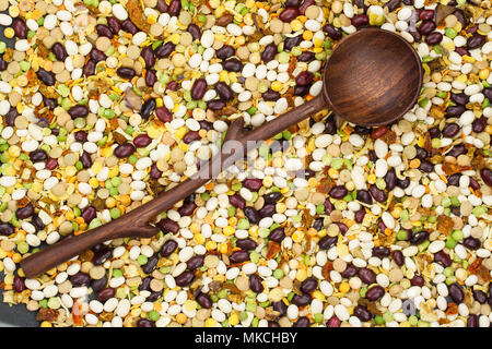 Bohnen, Erbsen mischen mit Gewürzen und Löffel aus Holz Stockfoto