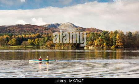 Zwei Personen Paddel Kanu in Windermere See in Ambleside, unter den Bergen von Langdale und Herbst Wald in England Lake District National Par Stockfoto