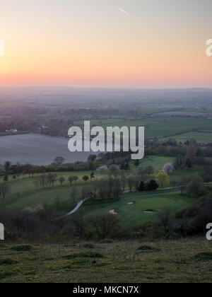 Die Sonne geht über Felder und Dörfer in die landwirtschaftliche Landschaft des Aylesbury Vale, von Combe Hügel auf dem Steilhang der Chiltern Hills gesehen. Stockfoto