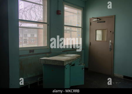 Schmutz, Rost Behandlung Tabelle innerhalb des Gefängnisses Krankenhaus mit Zaun und Stacheldraht durch das Fenster. Stockfoto