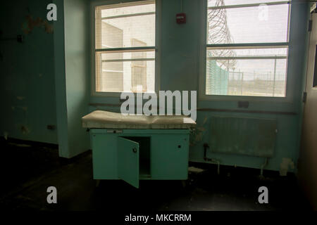 Schmutz, Rost Behandlung Tabelle innerhalb des Gefängnisses Krankenhaus mit Zaun und Stacheldraht durch das Fenster. Stockfoto